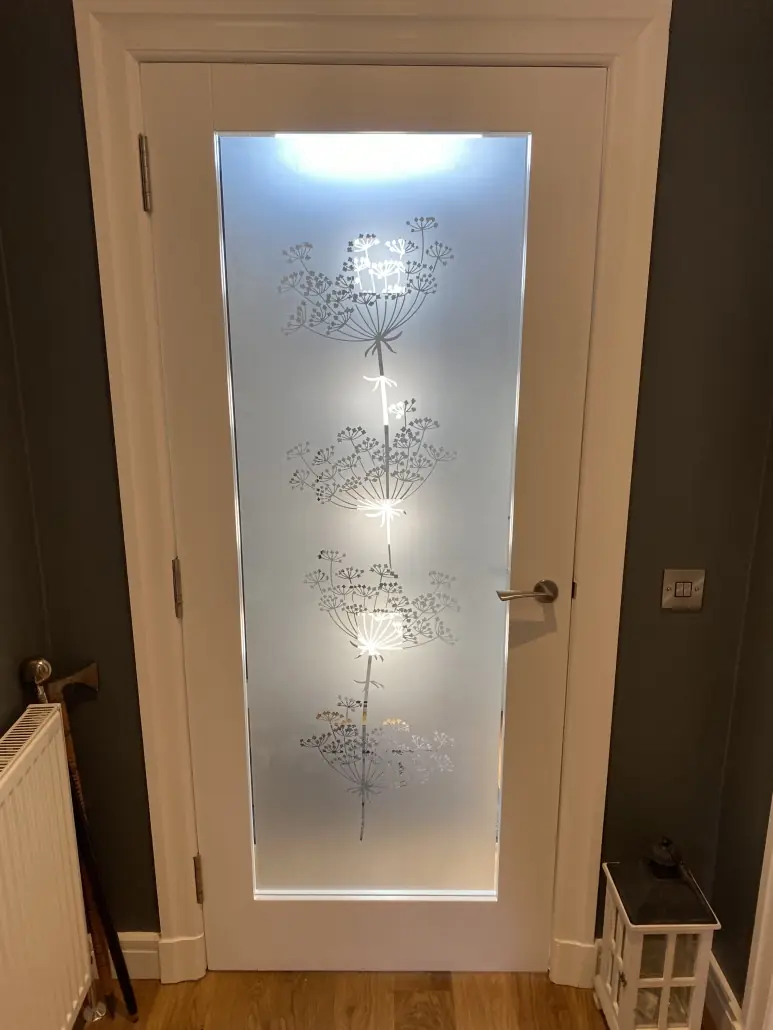Interior glazed door with an etched effect vinyl dandelion design applied to the glass