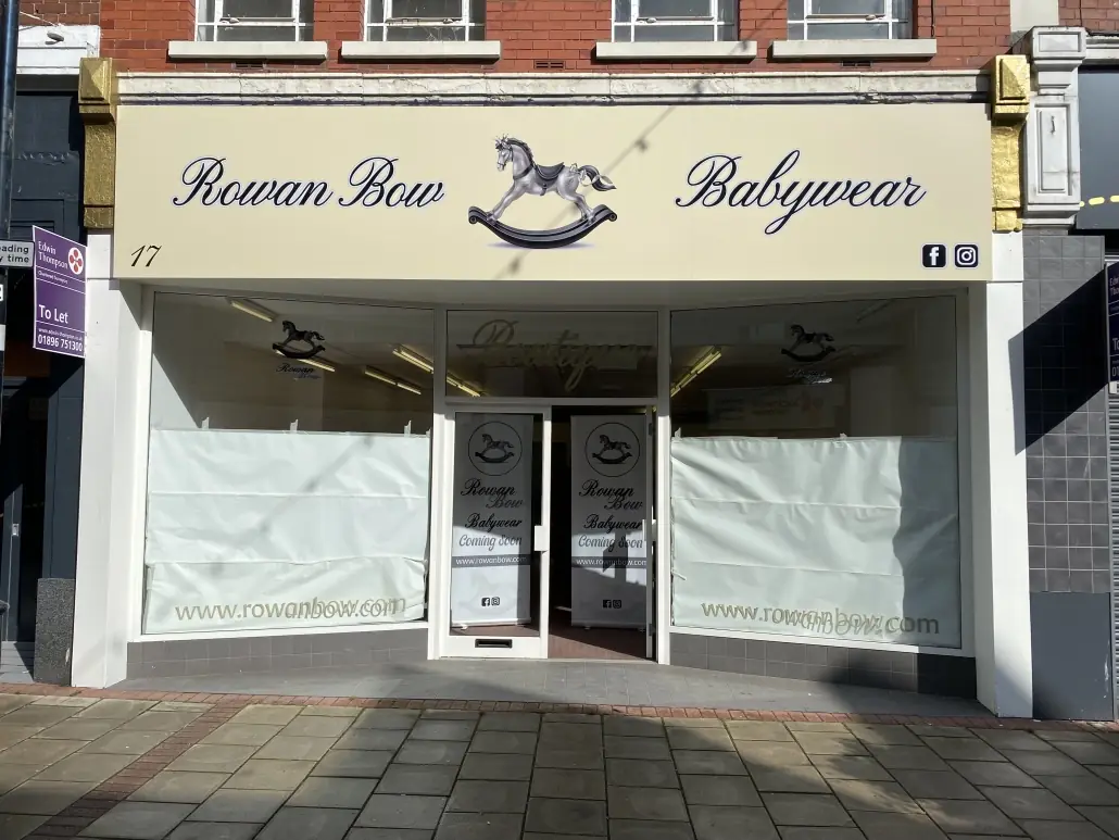 Rowan Bow Babywear shop front with a cream fascia sign and frosted window graphics