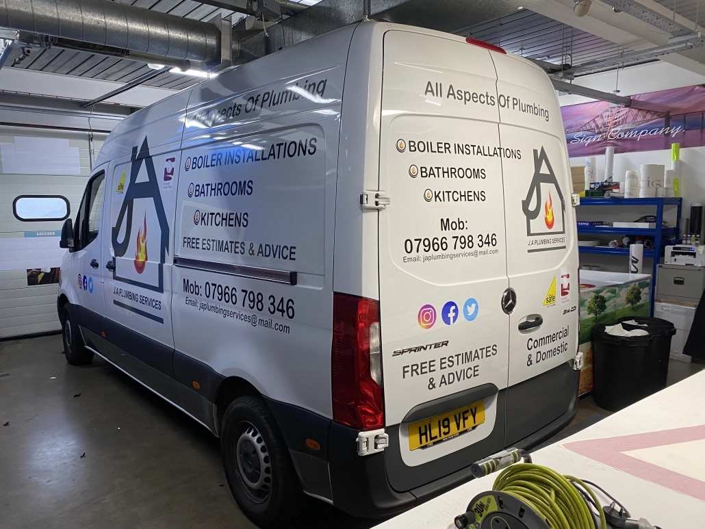 JA Plumbing Services van with cut vinyl rear door graphics listing services and contact numbers