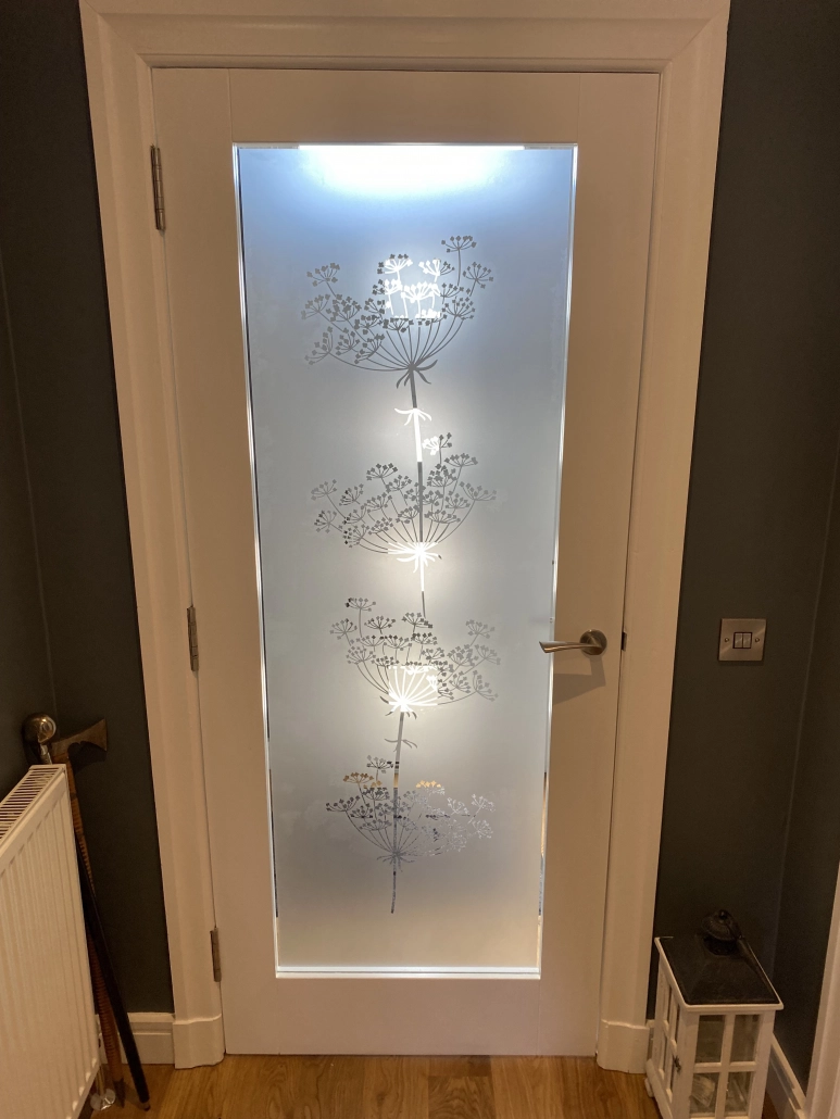 Interior glazed door with an etched effect vinyl dandelion design applied to the glass