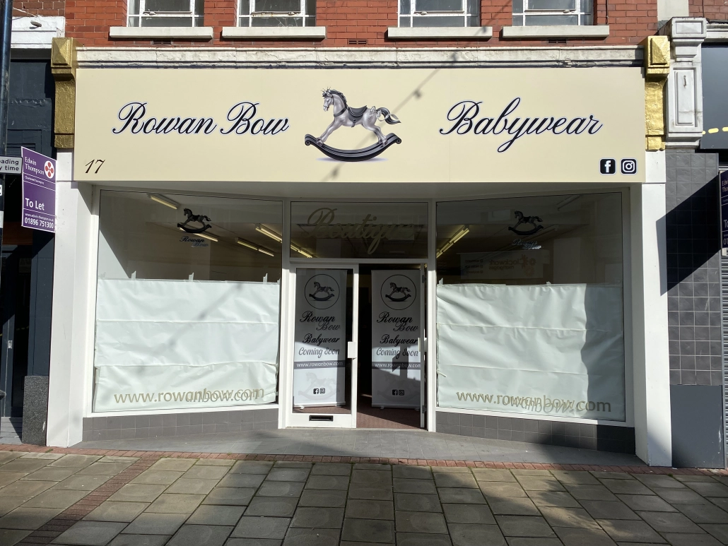 Rowan Bow Babywear shop front with a cream fascia sign and frosted window graphics
